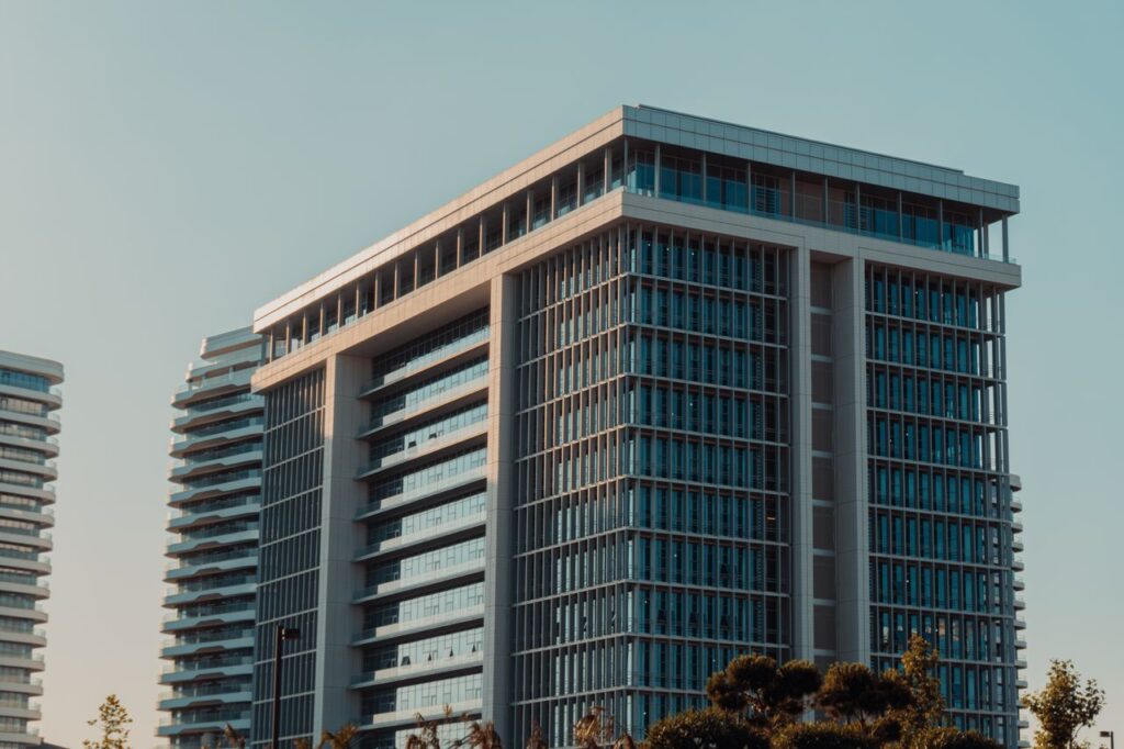 A modern highrise building with glass facade against a clear sky, showcasing urban architecture.